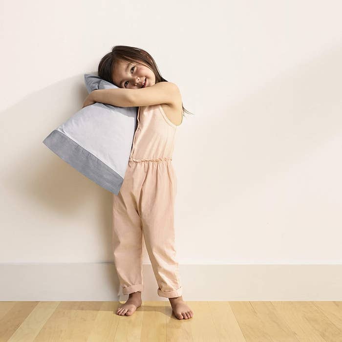 a child happily hugging the pillow 