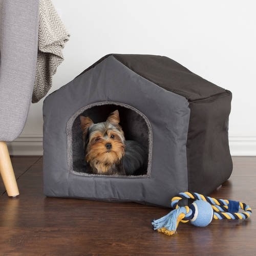 yorkie in a covered pet bed that looks like a house