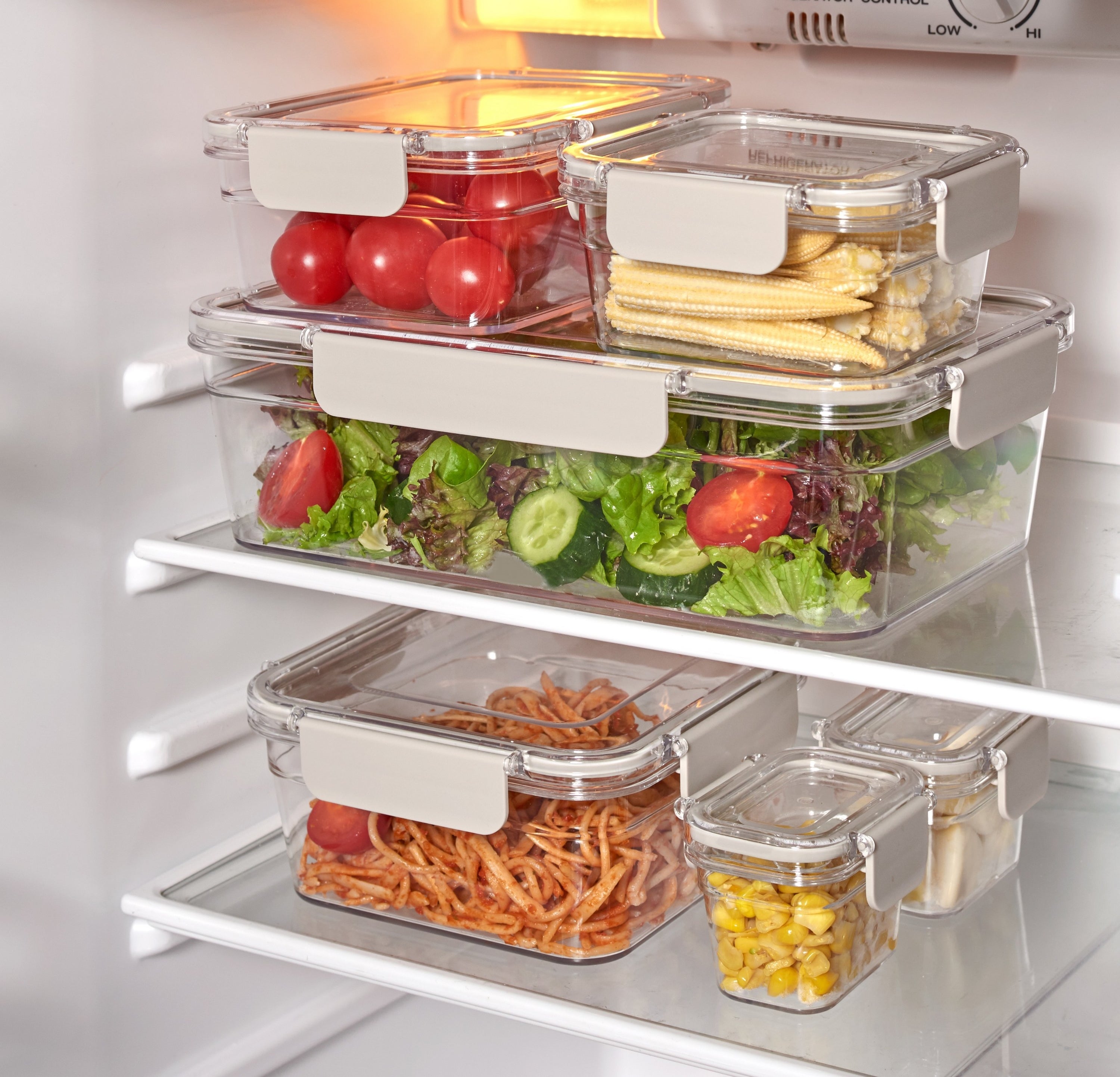 food storage containers with various kinds of food inside that are sitting in a fridge