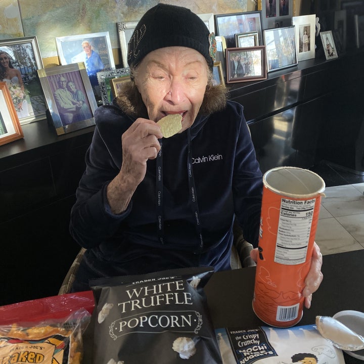 Grandma eating a potato chip.