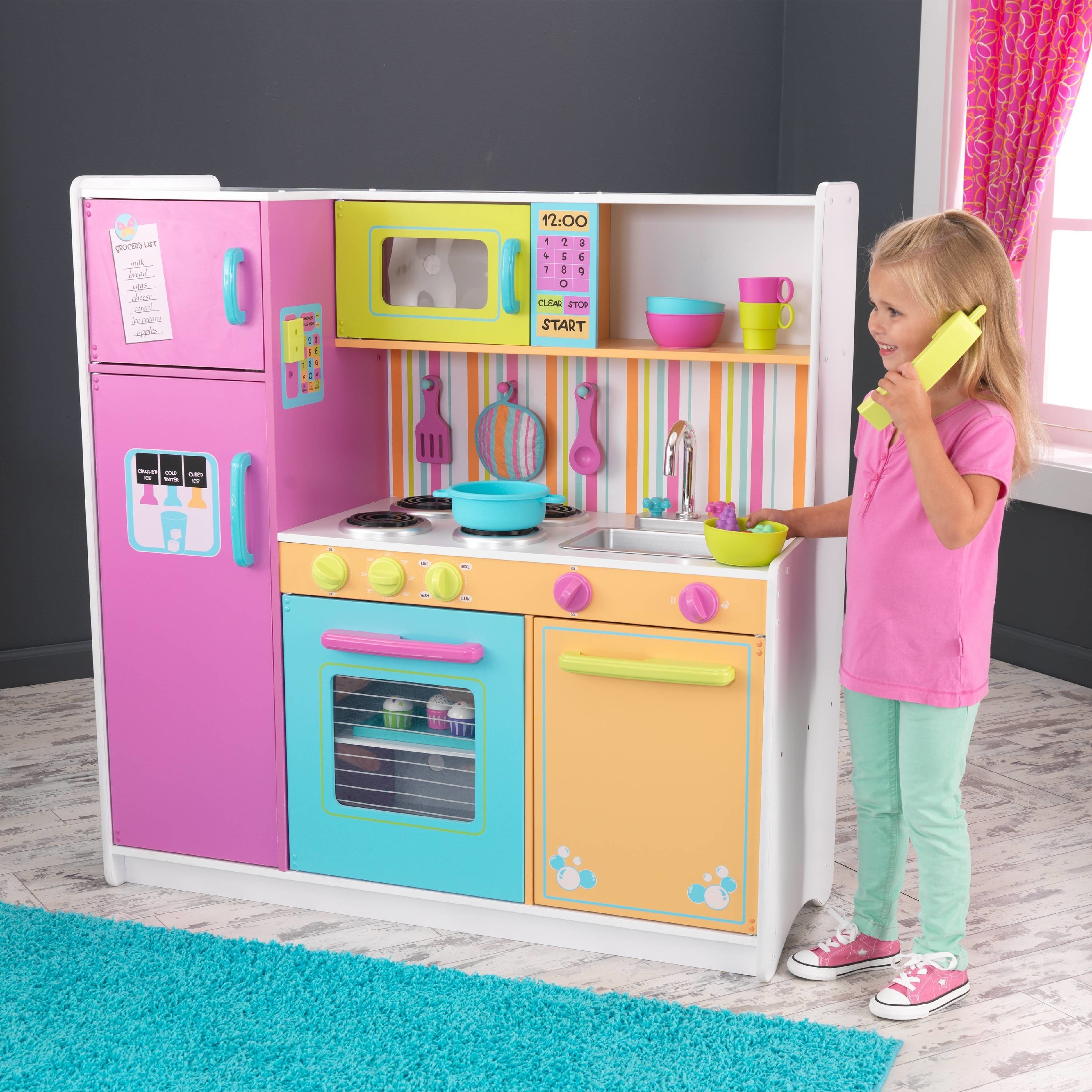 little kid playing with a brightly colored kid kitchen