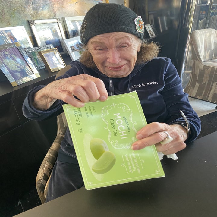 My grandma holding a box of green tea mochi.