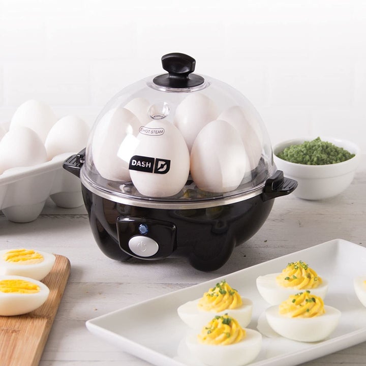 Black Dash Rapid Egg cooker heating up hard-boiled eggs next to plate with deviled eggs
