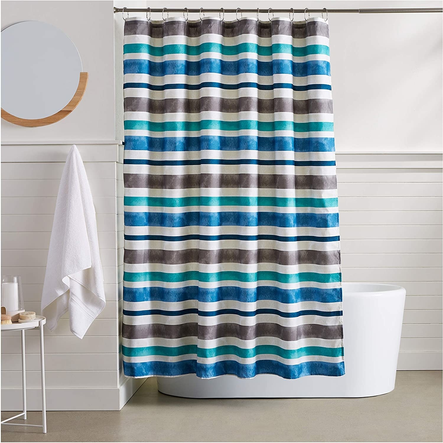 A striped shower curtain hung next to an elegant free-standing tub