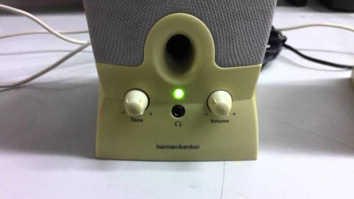 Close-up of a external computer speaker with the green light on