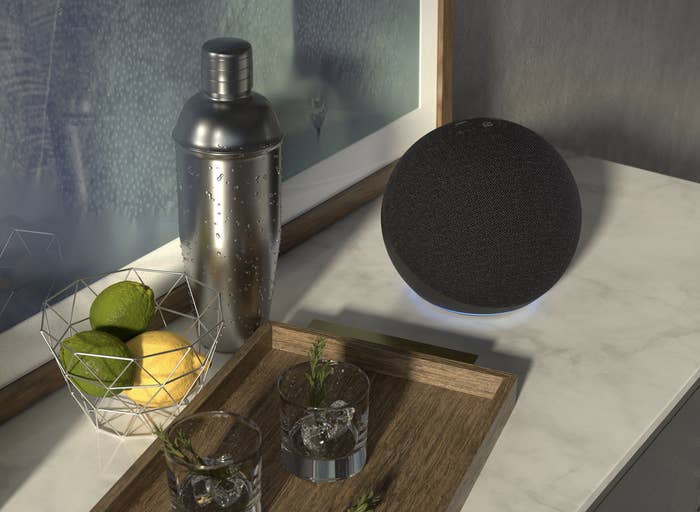 the sphere-shaped amazon echo on a counter next to a shaker and two tumblers
