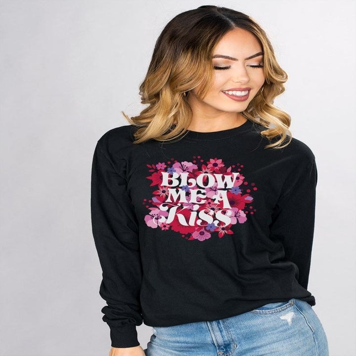 Black long-sleeved tee with flowers and the words "Blow me a kiss"
