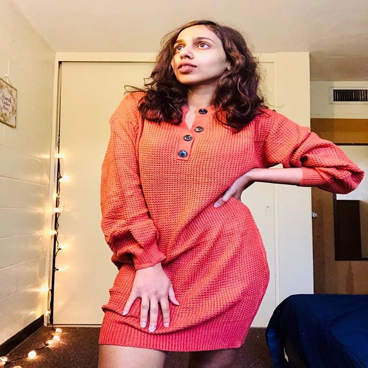 Reviewer wearing the mid-thigh length dress in orange with v-neck and buttons down the middle
