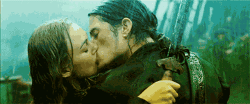 Will and Elizabeth kissing and holding their swords