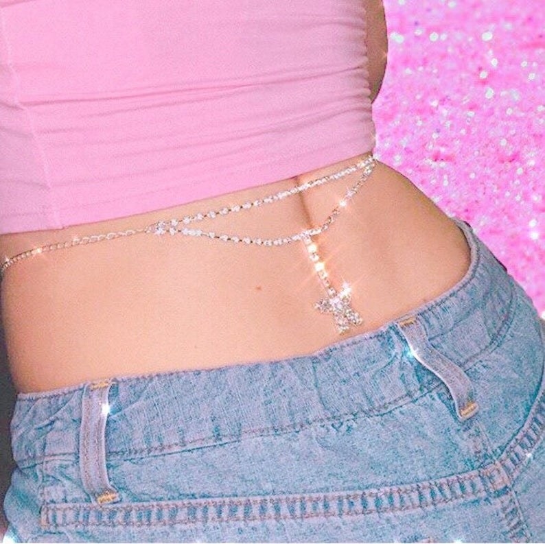Photo of a woman wearing a crop top and a waist chain with a star hanging off of it