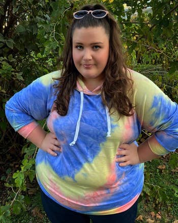 A different reviewer wearing the tie-dye sweatshirt in blue, yellow, and pink