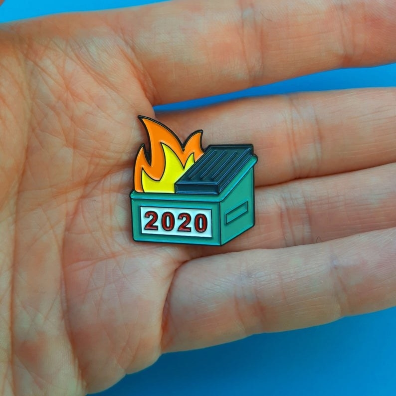 a hand holding the very small 2020 dumpster fire pin