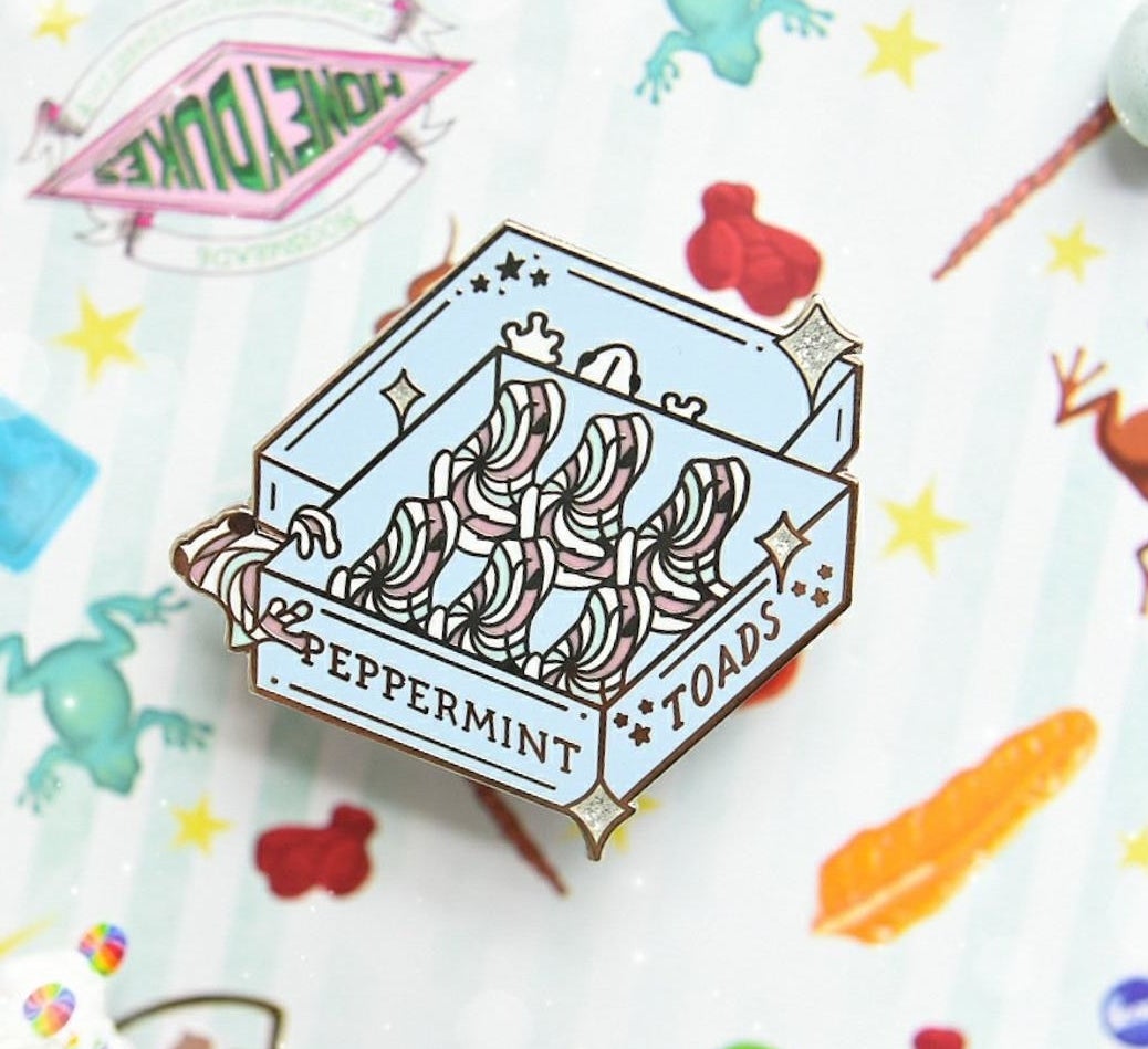 the blue enamel pin with the peppermint toad design