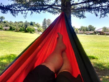 Reviewer hanging in a red hammock outside