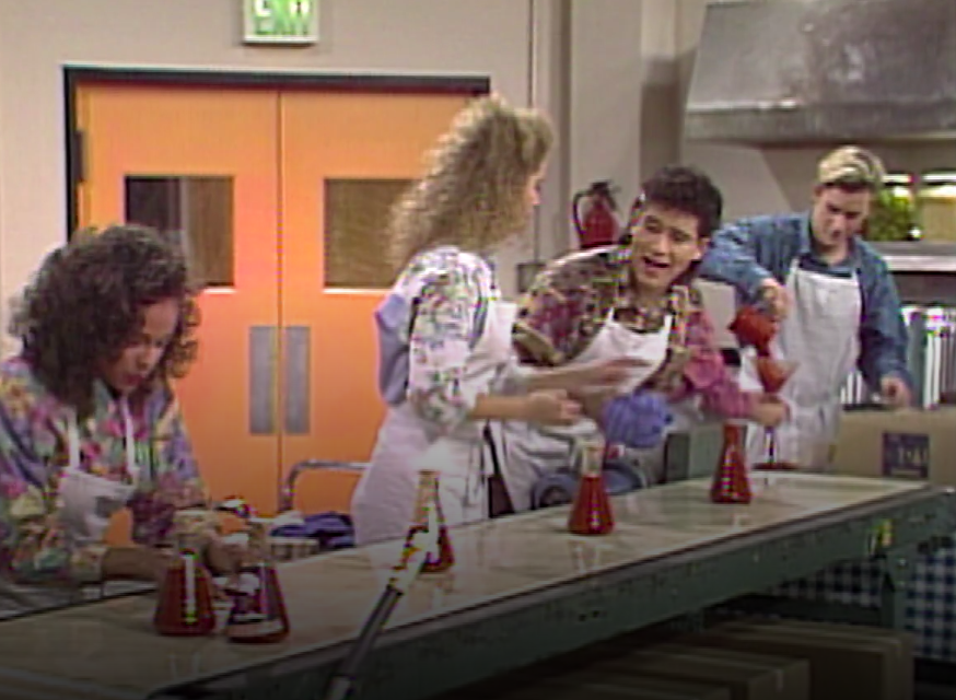 The friends bottle sauce on an assembly line