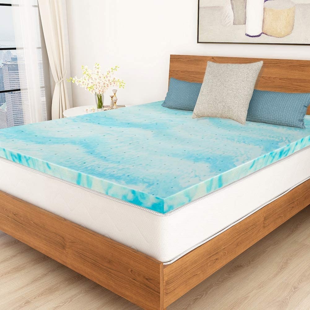 The swirly blue topper on a bed