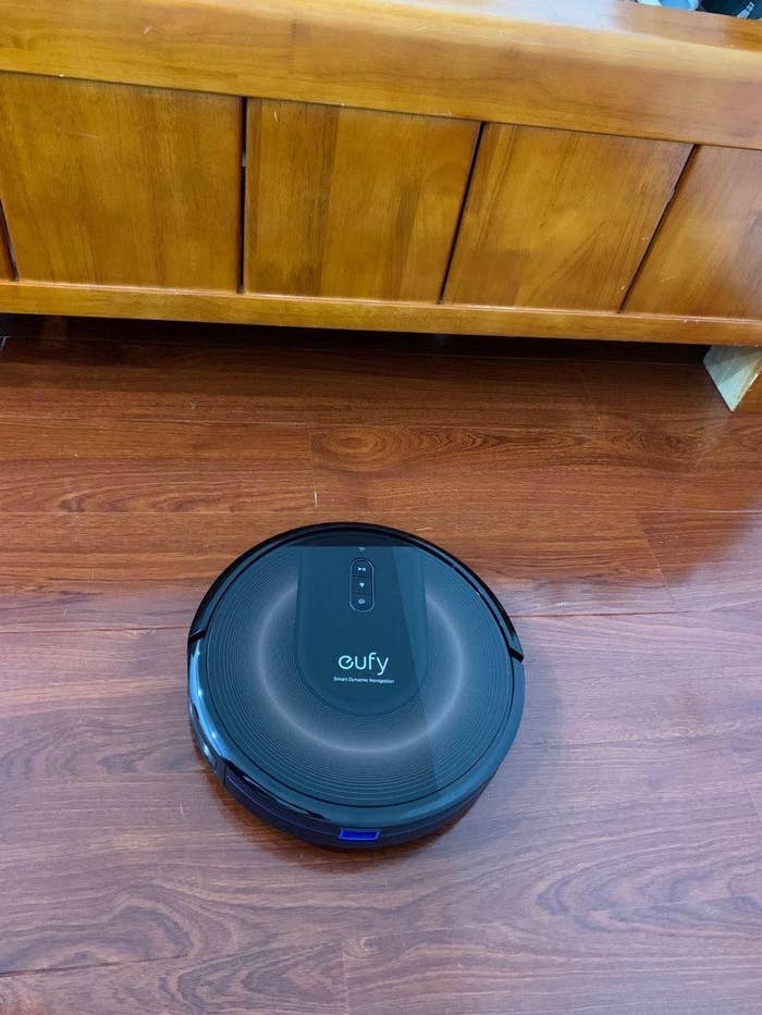 Black robot vacuum on hardwood floor