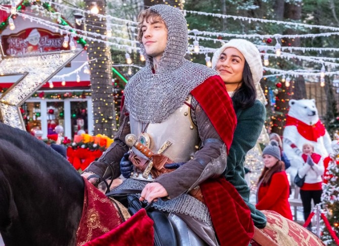 Still from The Knight Before Christmas: Vanessa Hudgens and Josh Whitehouse ride a horse together; he is wearing a knight costume