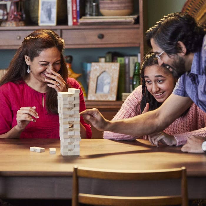 A family plays a game of Jenga