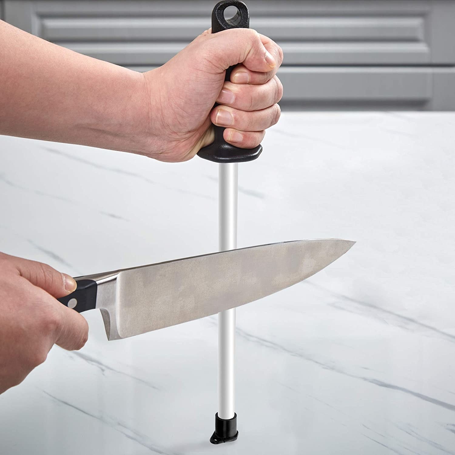 A person sharpens a knife against a rod