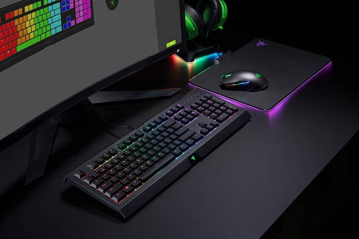 gaming keyboard next to a light up mat under a computer