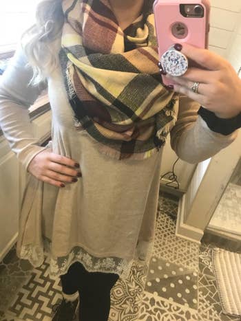 Reviewer wearing scarf with beige, black and red tones
