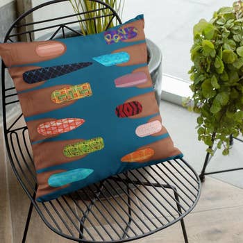Square throw pillow with fingers on each side – each with a different manicured fingernail 