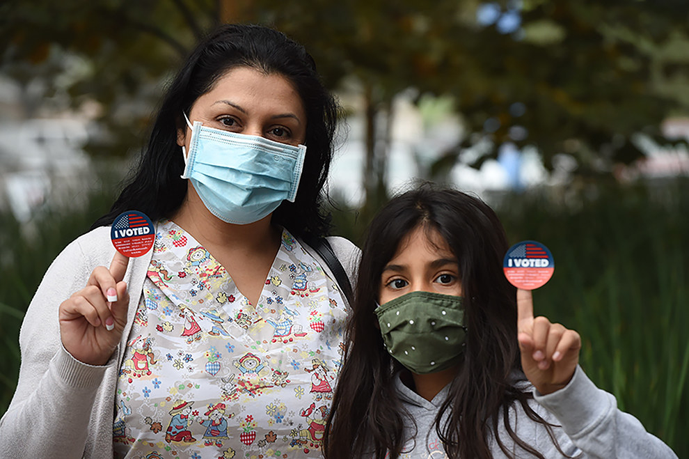 Mother and daughter showing off their I Voted stickers.