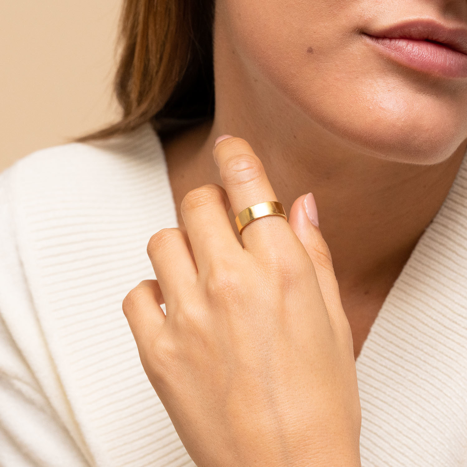 Model wearing gold ring on index finger