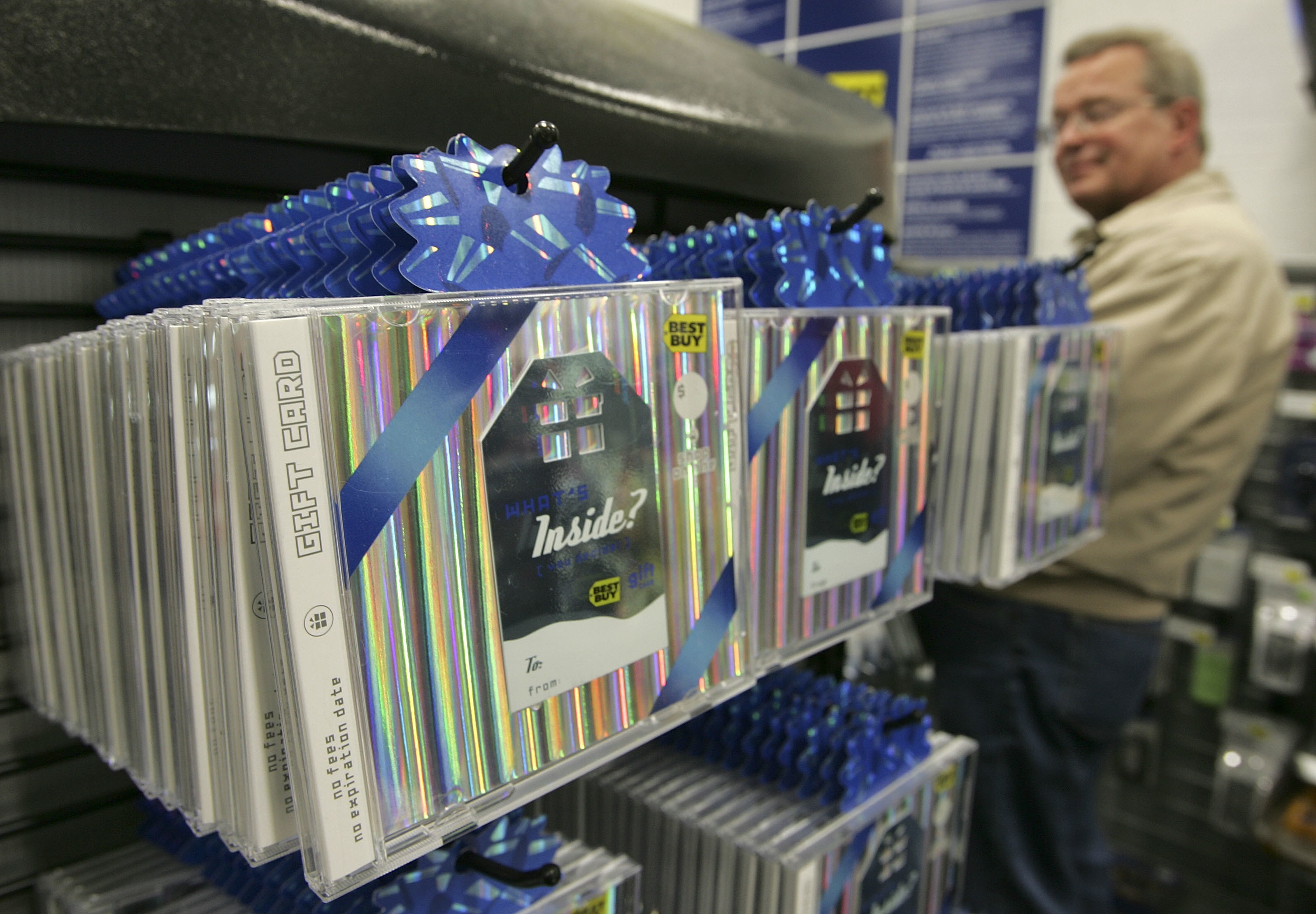 Best Buy gift cards in CD jewel cases hanging on an end cap 