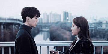 The Grim Reaper and Sunny look at one another on a bridge in the K Drama Goblin