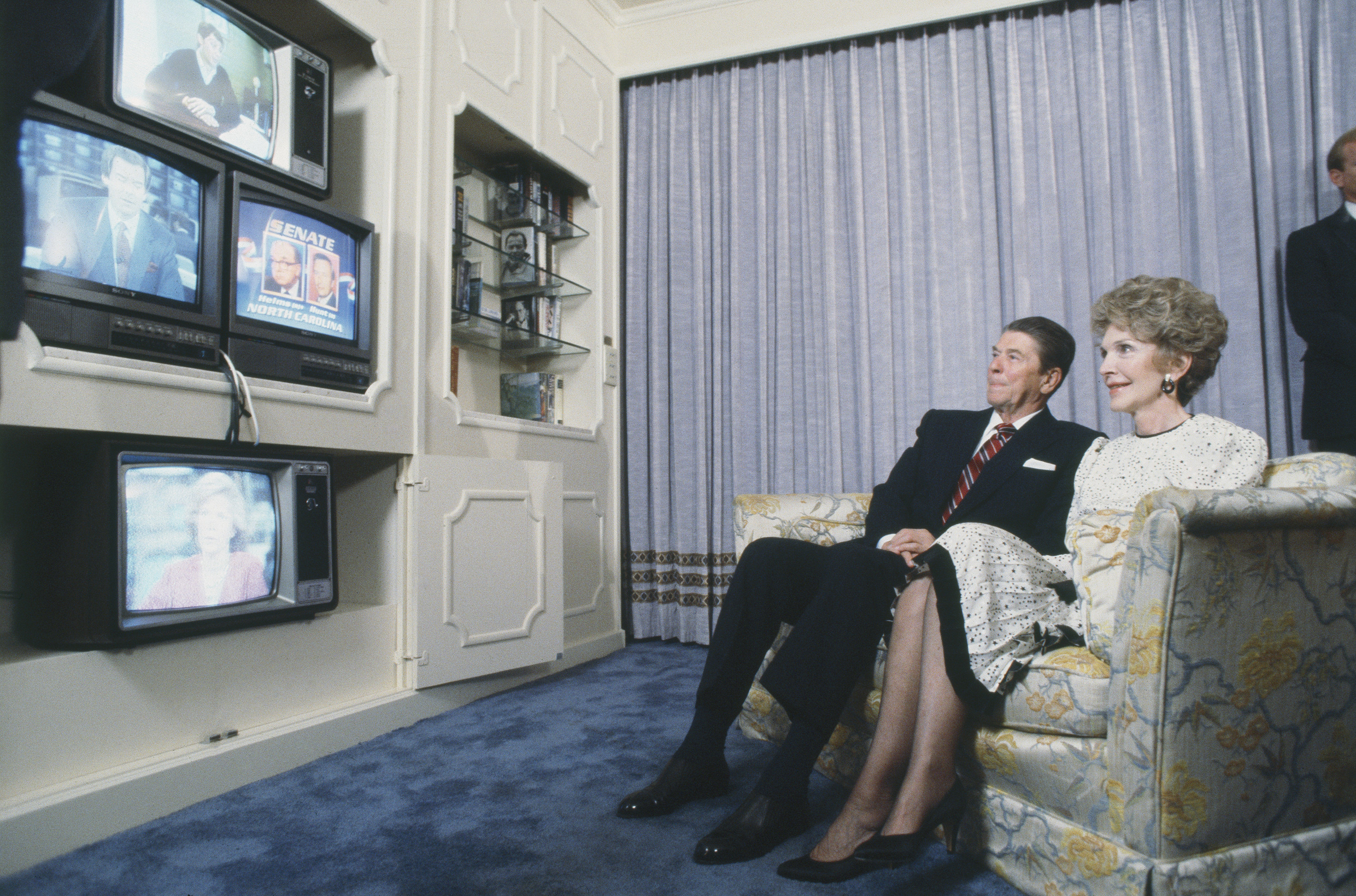 Ronald and Nancy Reagan watching multiple televisions