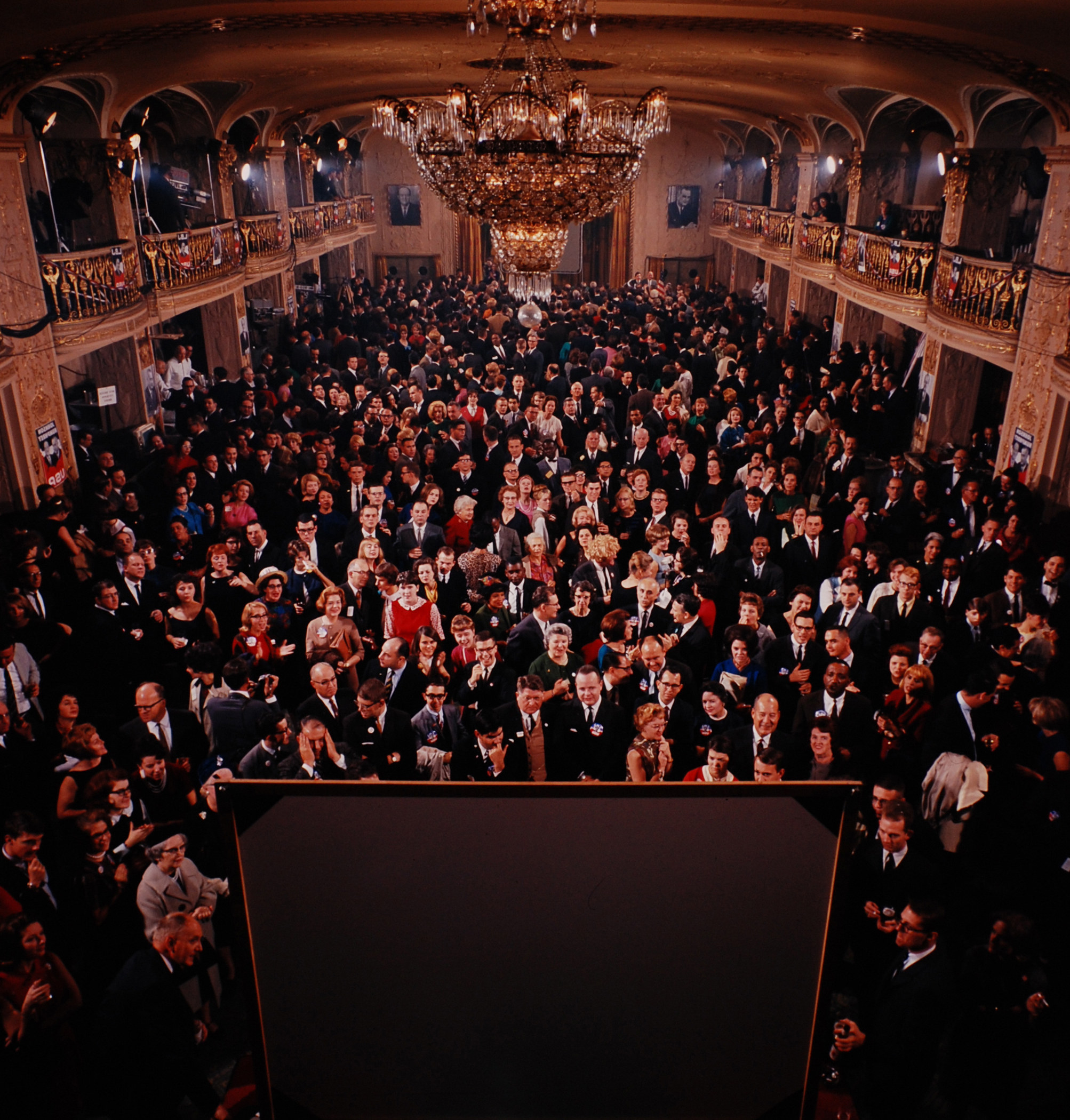 Crowd of people watching a screen, which we only see the back of