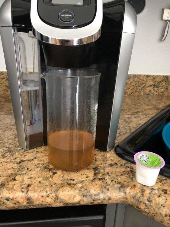 A reviewer photo of dirty-looking liquid that was cleaned out of the Keurig with the pod
