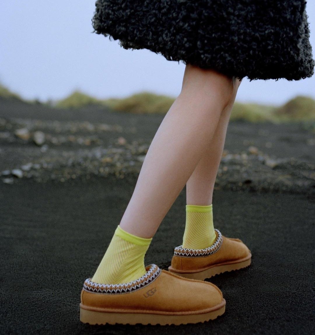 A person wearing Ugg slippers with socks