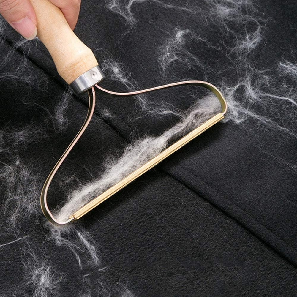 A person removing fluff from a fleece sweater with the comb