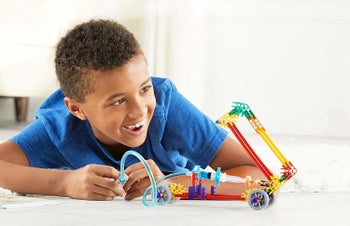 Child model playing with K'nex building kit

