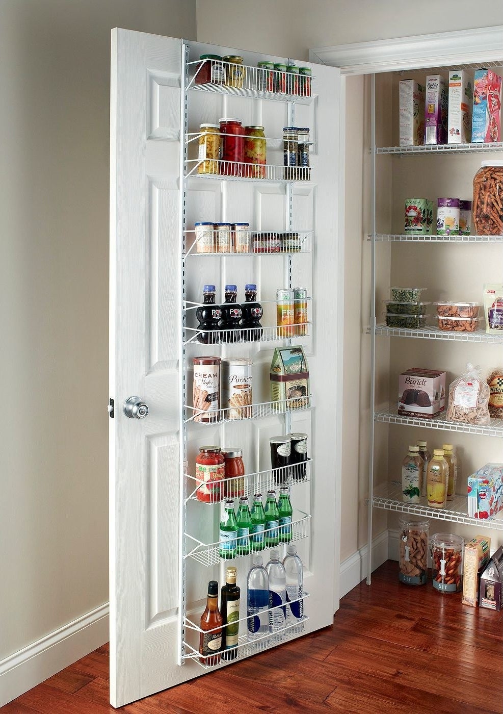 White wire rack behind door with canned goods, bottles of water, and more pantry items