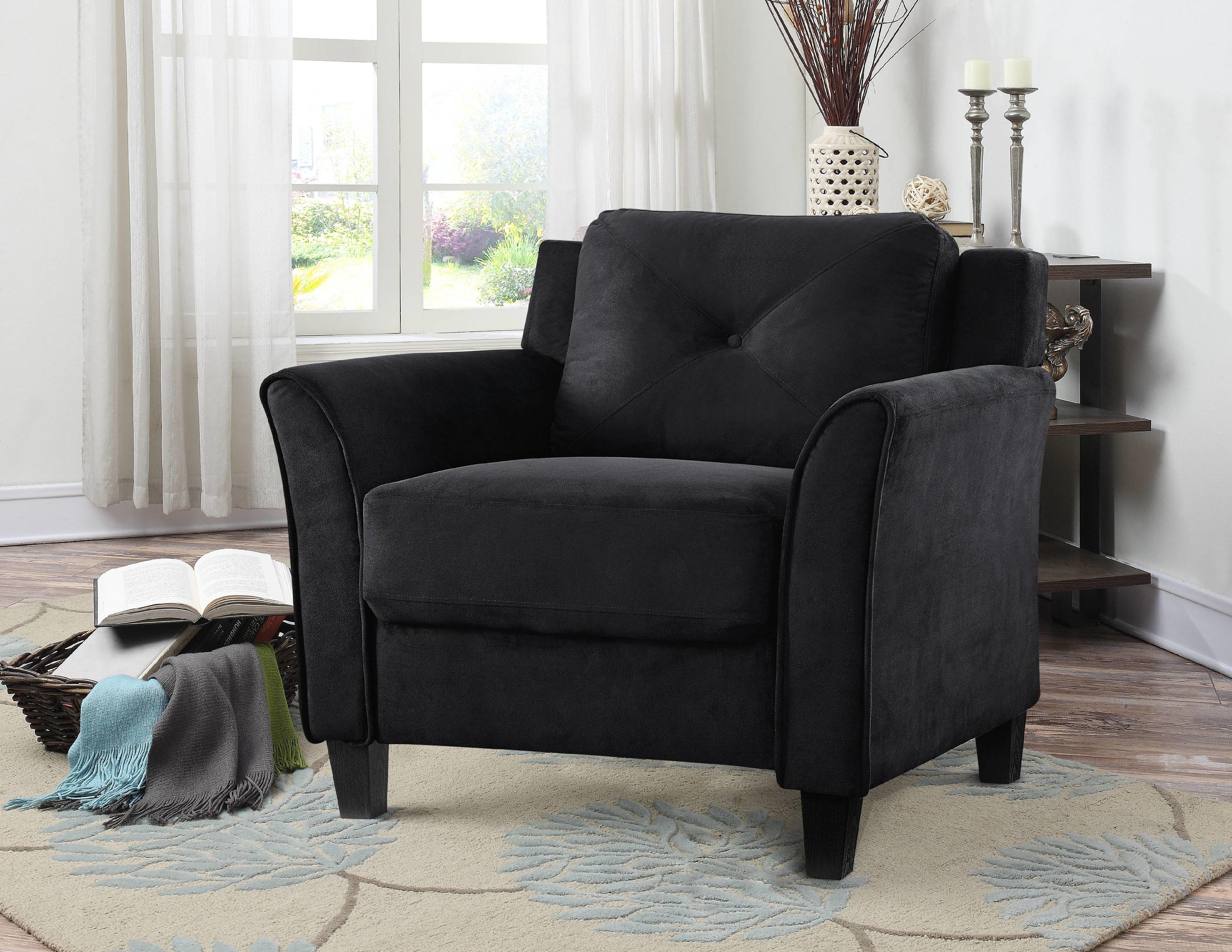 The chair in black, with arm rests that curve slightly outward, a low back, and deep seating area