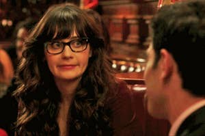On the left, Jess from "New Girl" shifting her eyes and doing a strange little smile