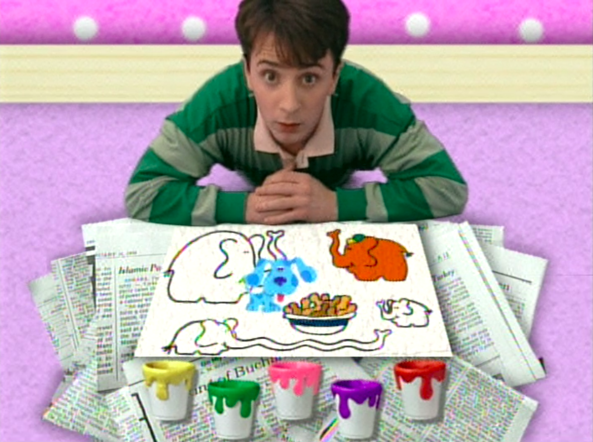 Steve in front of paint buckets and the drawing of elephants Blue is on top of 