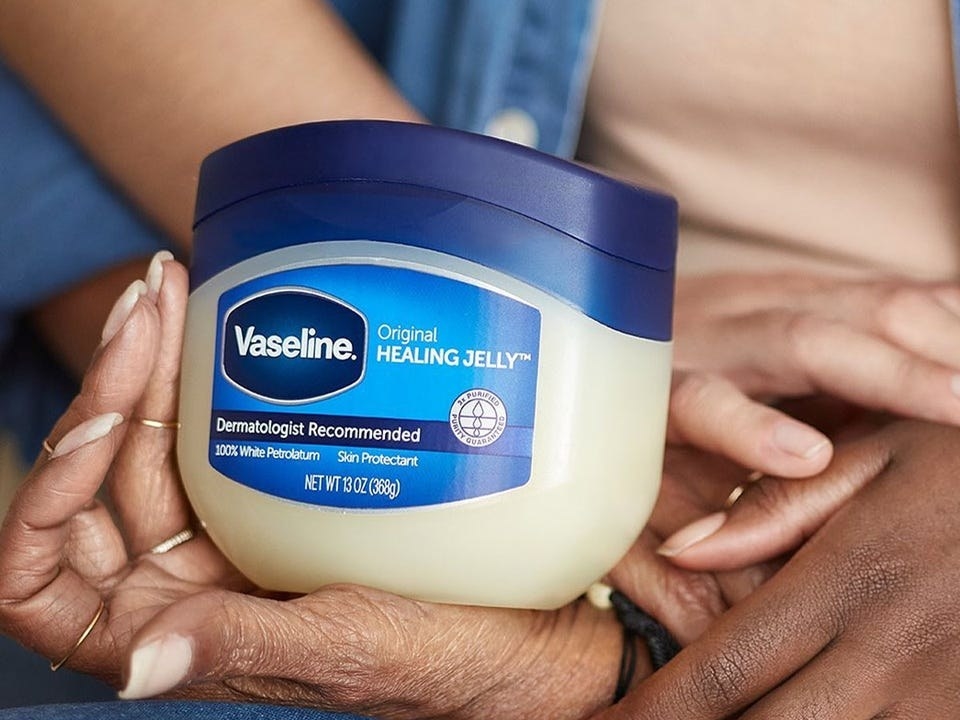 hands holding tub of vaseline