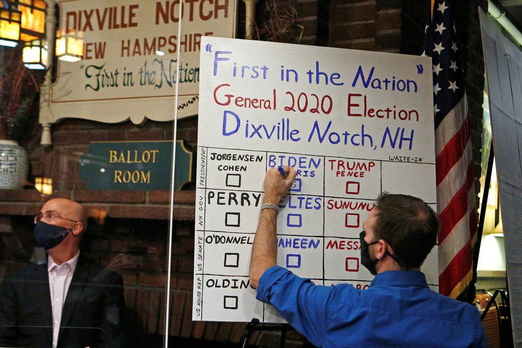 A handwritten vote count is updated by a man in marker