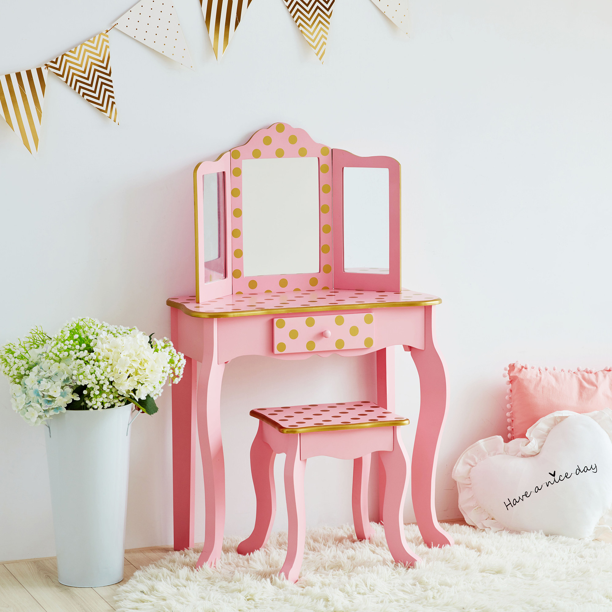 A pink and gold polka dotted vanity in a room