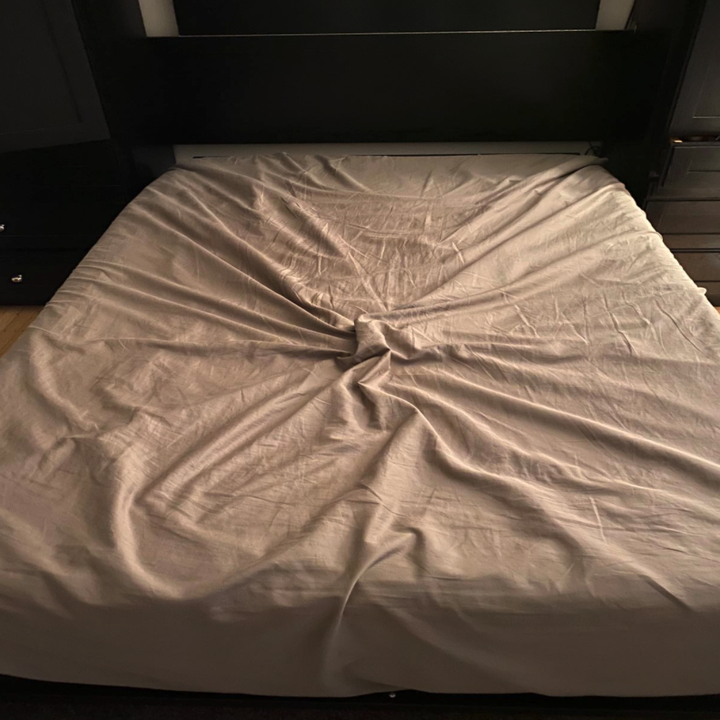 reviewer photo showing their bed sheets in a wrinkled mess on their bed 