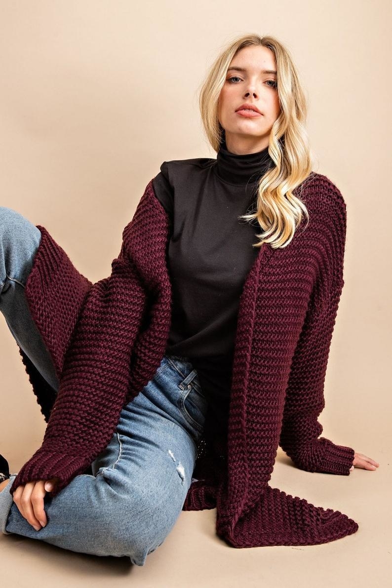 a model wearing the cardigan in red