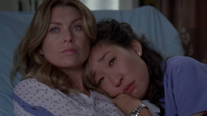Meredith and Cristina hugging in a hospital bed