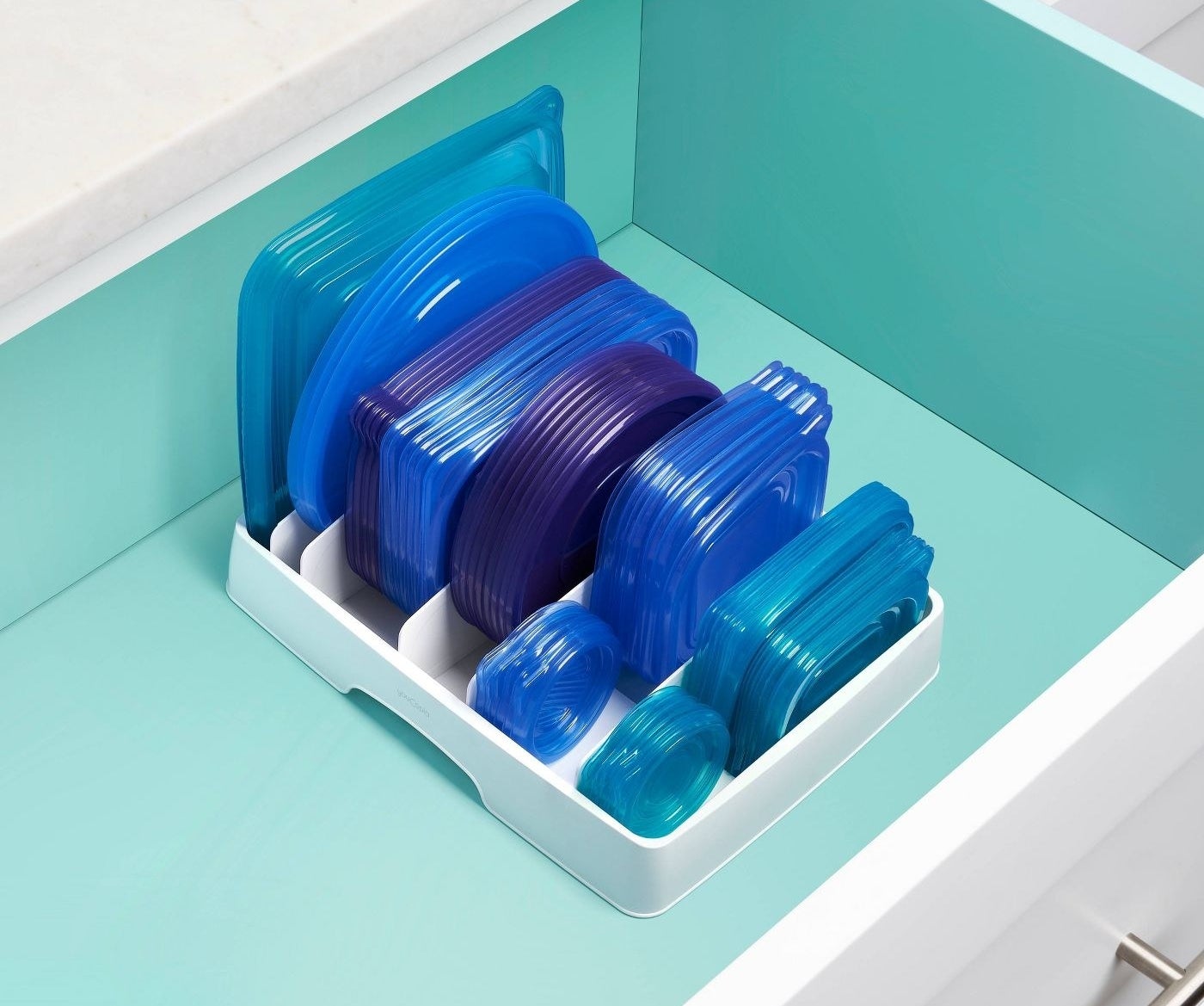White lid organizer with neatly stacked blue plastic lids in a drawer