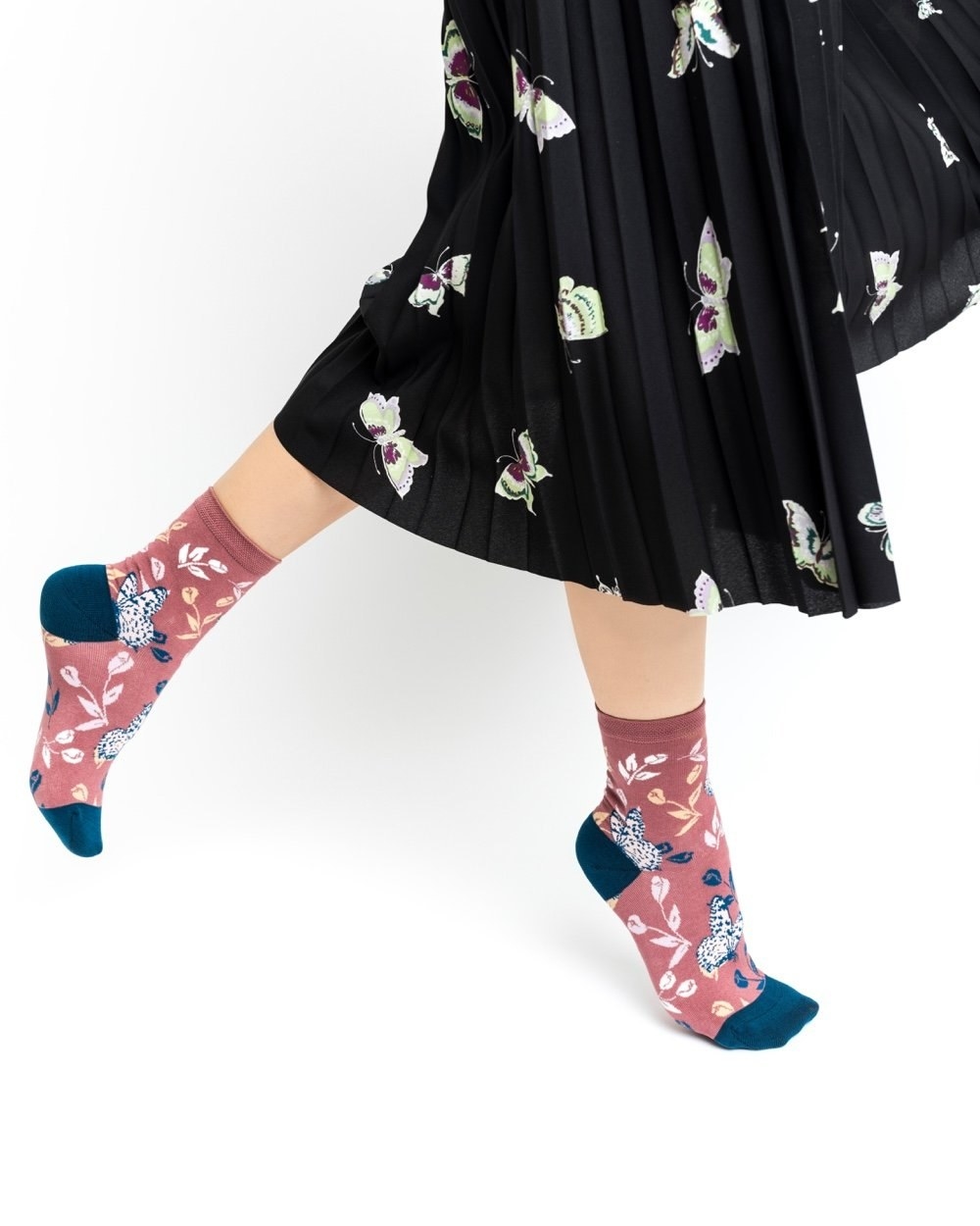 A model wearing the tossed butterfly ankle sock