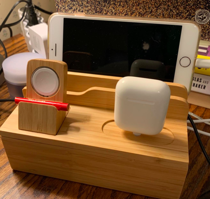 reviewer photo showing the bamboo caddy holding an iPhone, AirPods, and chapstick